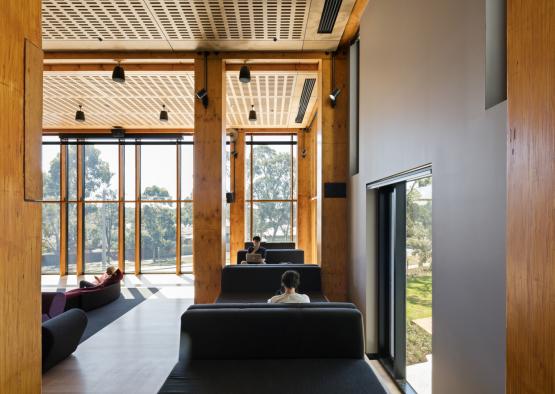 a room with a large window and a couple of people sitting on couches