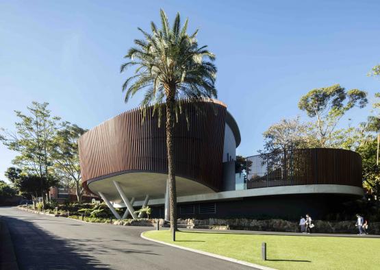 a building with a curved roof and palm trees