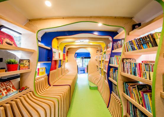 a room with many chairs and books on shelves