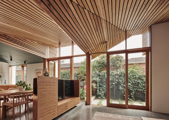 a room with a wood ceiling and a table and chairs