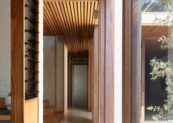 a hallway with wood beams and a white wall