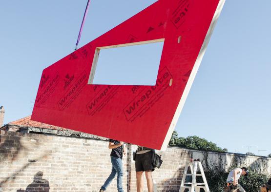 people holding a large piece of wood