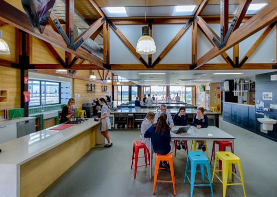 a group of people sitting at a table in a room with a large ceiling