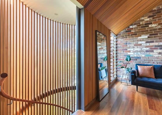 a room with a curved staircase and a mirror