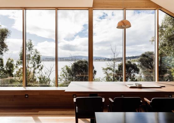 a room with large windows and a table and chairs