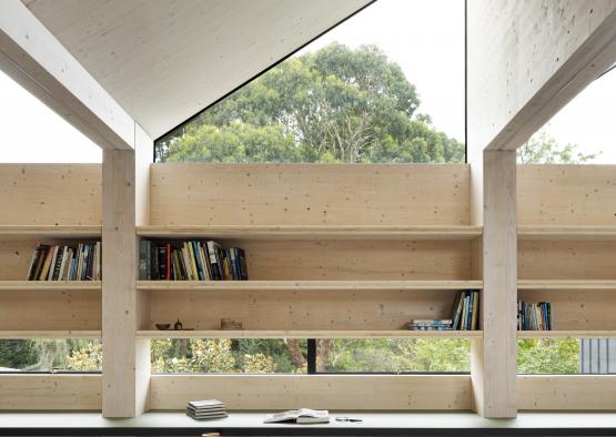 a room with a window and a shelf with books