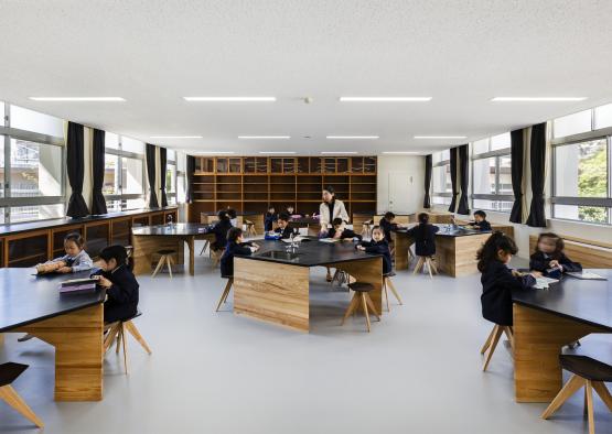 a group of children sitting at tables in a classroom