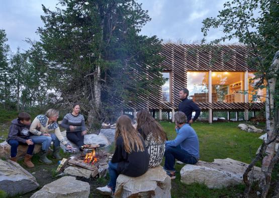 a group of people sitting around a fire in front of a building