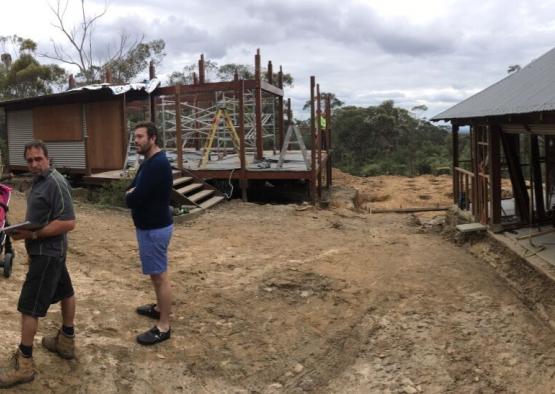 a man standing in dirt next to a building