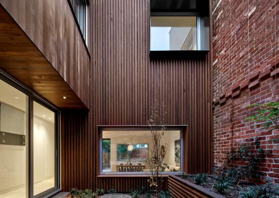 a courtyard of a building with a brick wall and a garden