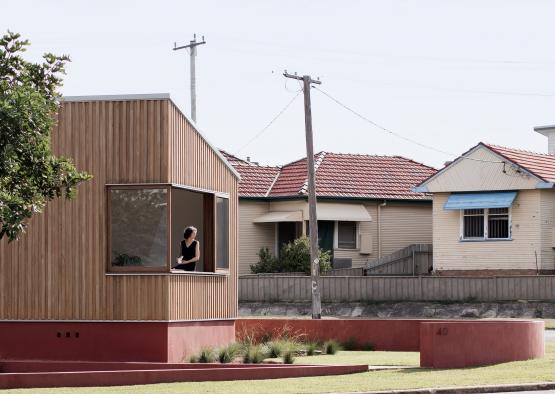 a woman standing in a window of a small house