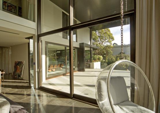 a glass door with a chair in a room with a patio