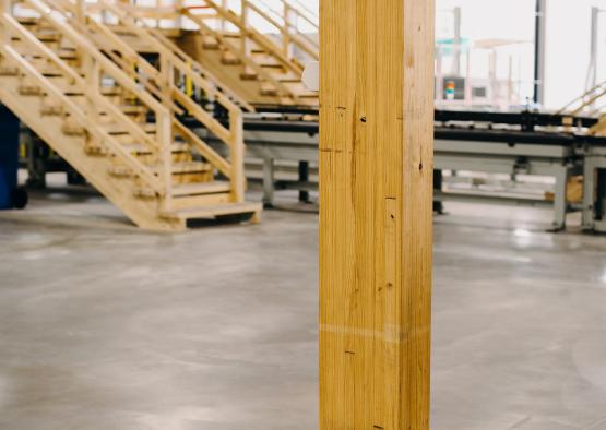 a wooden post in a room with stairs