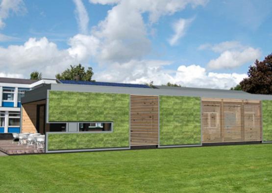 a building with green walls and a green lawn