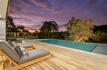 a deck with a pool and a deck with a couch and a bench