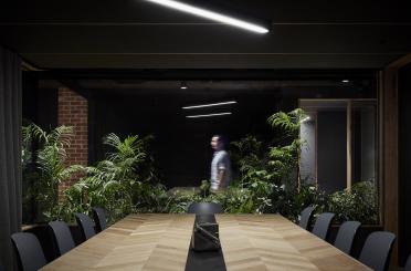 a room with a table and chairs and a man standing in the background