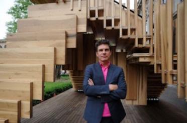 a man standing in front of a wooden staircase