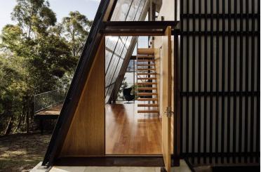 a triangular building with a wooden door and stairs