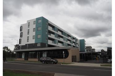 a building with a parking lot and a car parked on the side of the road