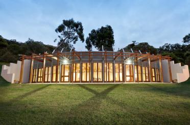 a building with a glass roof and a green lawn