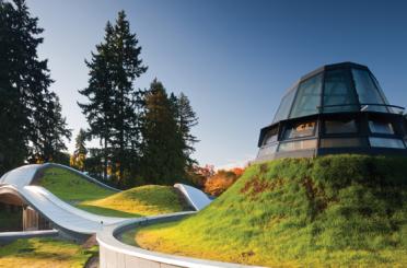 a building on a hill with grass and trees