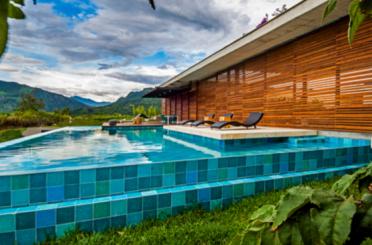 a pool with chairs and a building in the background