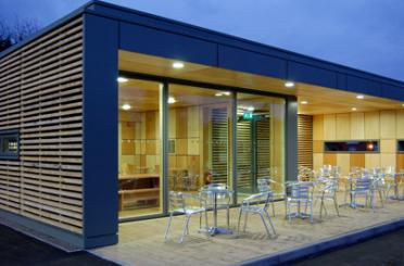 a building with a glass wall and tables and chairs